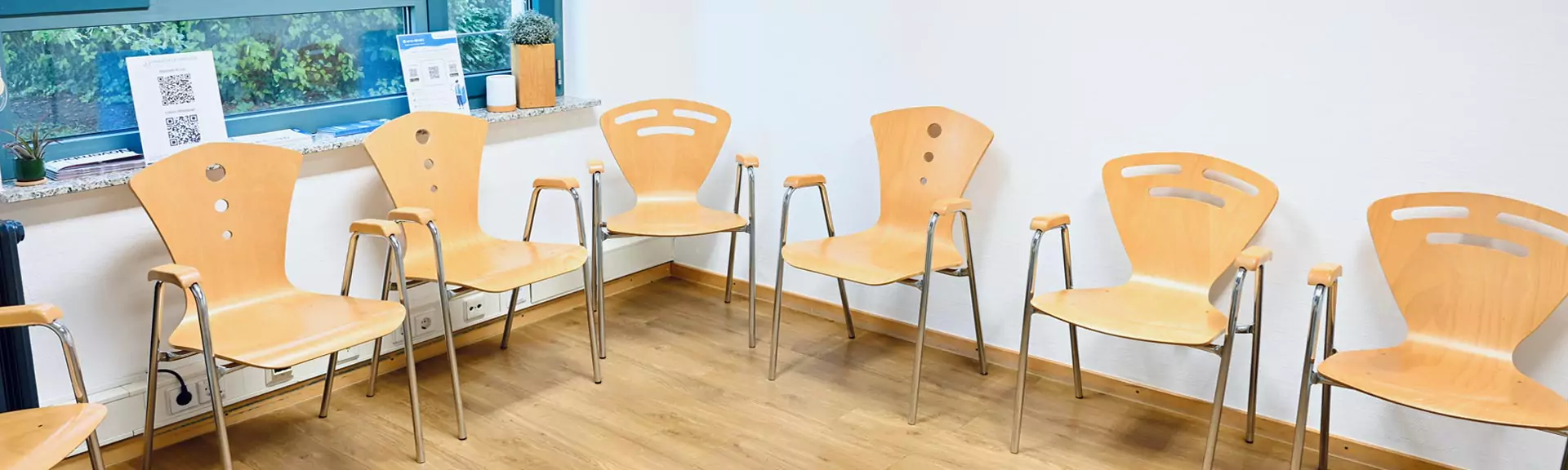 wartezimmer Wartezimmer mit mehreren Holzstühlen und Bildern